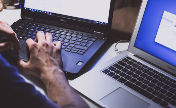 hands on two laptops